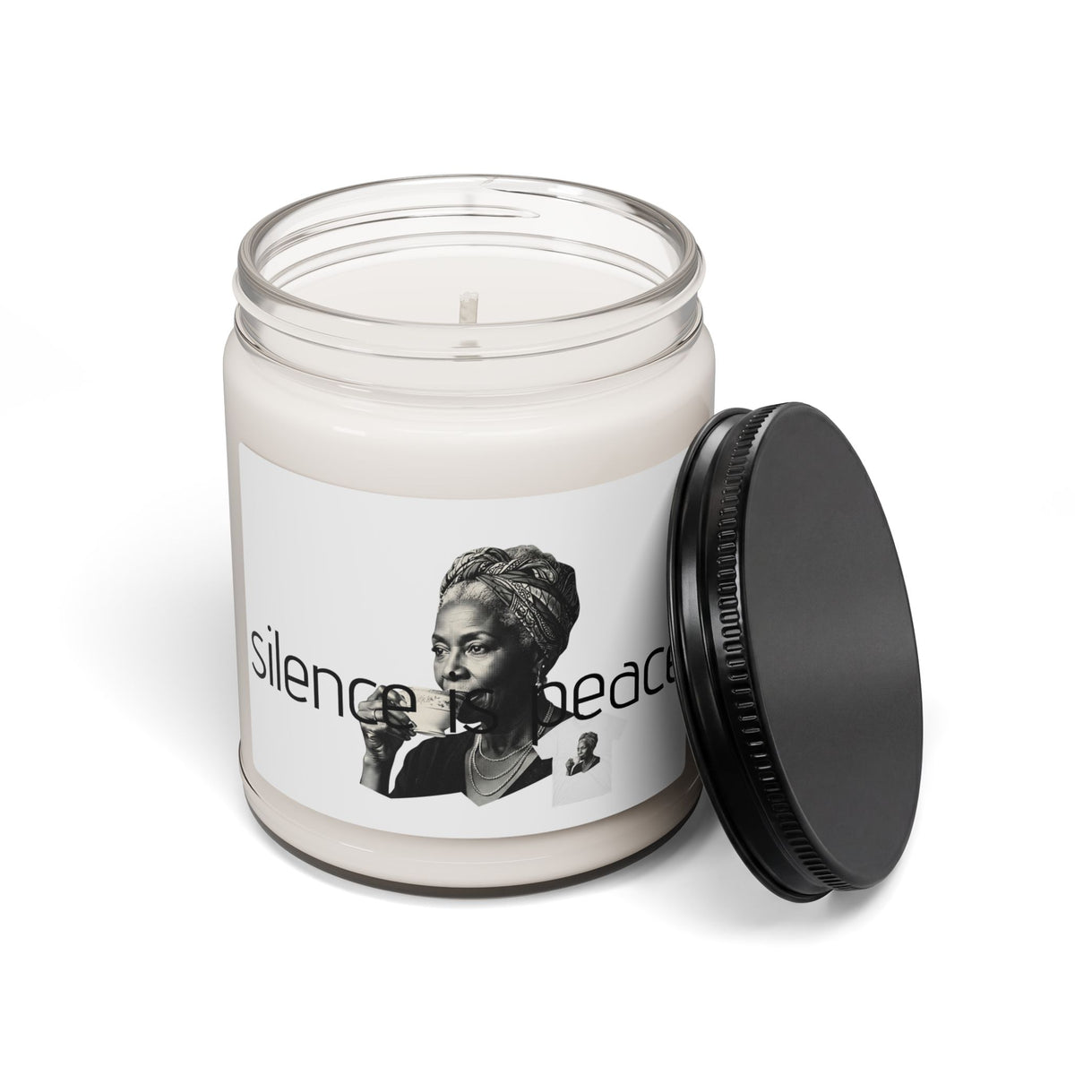 A white soy wax candle in a clear glass jar with a white label  and  white portrait text shown with a black screw top lid leaning  against the jar on  a white background