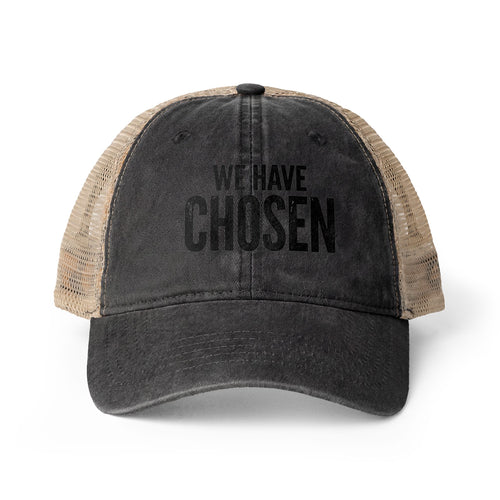 A distressed black trucker hat with beige mesh back panels and the text 'WE HAVE CHOSEN' printed in black on the front, shown against a plain white background.