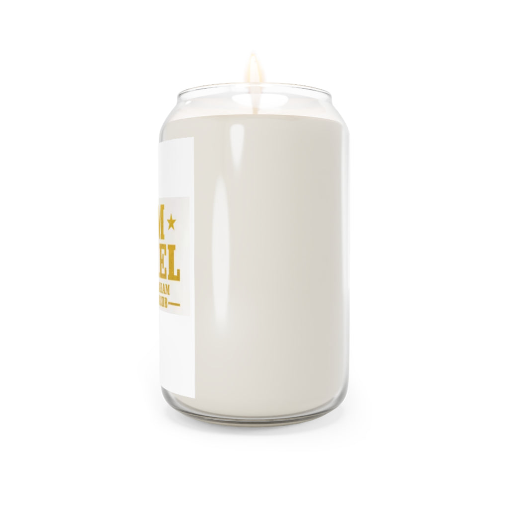 A large white candle in a clear glass jar with a single wick and a white label featuring gold text, shown against a plain white background.